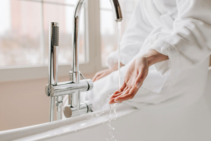 Woman washing hand in washbasin